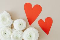 Kaboompics - White Flowers and Two Red Paper Hearts in an Overhead Flat Lay