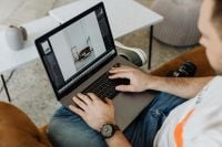 Kaboompics - Man Retouching a Photo on MacBook in a Home Workspace
