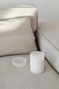 Kaboompics - White Candle Mockup with Detached Lid on a Neutral Sofa