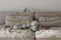 Kaboompics - Metallic Confetti and Mirror Balls Scattered Across a Gray Couch