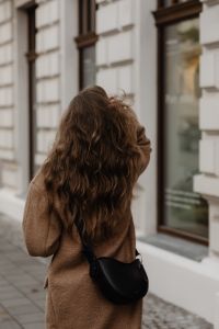 Kaboompics - Woman with Long Wavy Hair Walking Past City Windows