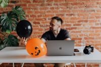 Kaboompics - Halloween Home Office Desk with MacBook, Camera and Pumpkin Balloon