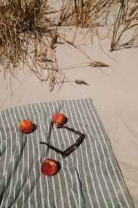 Kaboompics - Peaches and Sunglasses on a Striped Beach Towel