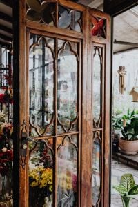 Kaboompics - Carved Wooden Glass Door Framed by Potted Plants
