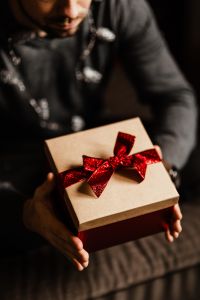 Kaboompics - Man Holding a Wrapped Present during Cozy Holiday Celebration