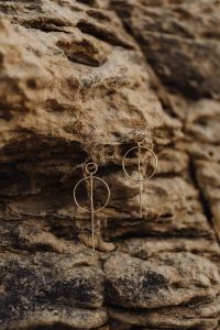 Kaboompics - Gold Circular Drop Earrings on Weathered Limestone