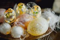 Kaboompics - Close-Up of Floral Glass Easter Eggs and White Feathers in a Dark, Soft-Focus Setting