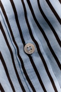 Kaboompics - Beige Button on Light Blue Brown Striped Shirt – Angled