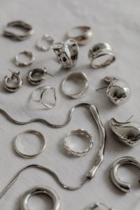 Kaboompics - Silver Jewelry and Chain Detail on White Fabric