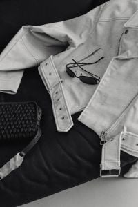 Kaboompics - Beige Jacket, Black Sunglasses and Woven Bag on a Leather Sofa