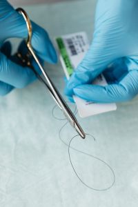 Kaboompics - Gloved Hands Preparing Dental Suture Material