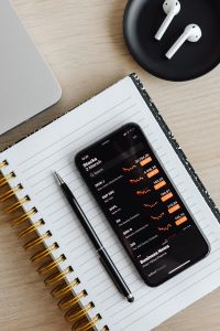 Kaboompics - Phone - stock exchange - charts - AirPods - laptop