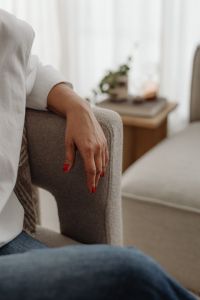 Kaboompics - Close-Up of Woman's Hand Resting on a Neutral Armchair