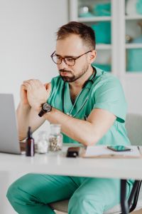 Kaboompics - Doctor Checking Wristwatch at Medical Desk