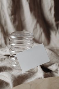 Kaboompics - Close-Up Landscape Card Mockup beside a Sculptural Glass Vase