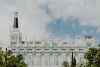 Kaboompics - Wide Madrid View of an Ornate White Facade, Dark Spire and Tree Canopies