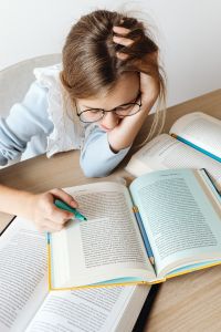 Kaboompics - Student Highlighting Textbook with Open Books