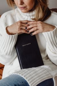 Kaboompics - Hands Resting Over a Bible with a Gold Cross Necklace