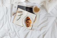 Kaboompics - Croissant, Eyeglasses and Fresh Coffee beside an Open Notebook in a Cozy Bed