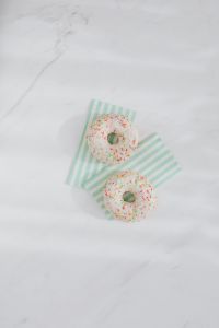 Kaboompics - Donuts on paper napkins placed on white marble