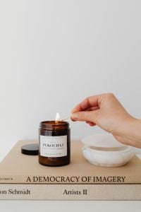Kaboompics - Hand Lighting an Amber Candle beside White Bowl and Copy Space