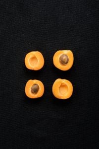 Kaboompics - Apricot Halves on a Black Textured Background