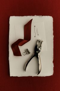 Kaboompics - White Stationery and Hole Punch with Burgundy Ribbon
