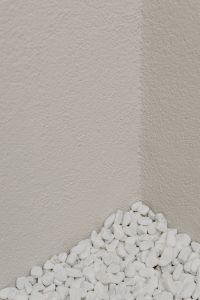 Kaboompics - Pale Rough Stone Wall with White Pebbles Along the Edge, Vertical Backdrop