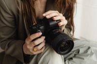 Kaboompics - Close Up of Young Female Photographer Holding DSLR Camera Lens