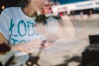 Kaboompics - Woman Drinking Coffee While Reading a Book in a Cafe