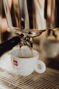 Espresso Extraction Into a White Cup at a Café Counter