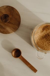 Kaboompics - Overhead Brown Sugar Pantry Flat Lay with Glass Jar and Wooden Spoon on a Neutral Background