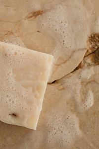 Kaboompics - Close-Up of a White Soap Bar on a Foamy Surface