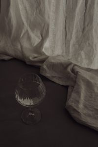 Kaboompics - Stemmed Glass on a Dark Table with Draped Linen Fabric