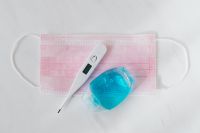 Kaboompics - Digital Thermometer and Blue Sanitizer on Pink Face Mask