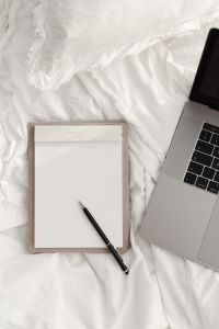 Kaboompics - Blank Notebook and Black Pen Beside a Laptop on White Sheets
