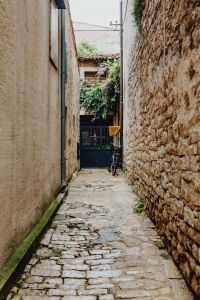 Kaboompics - Stone-Walled Rovinj Alley with Cobblestones, Bicycle and Vined Courtyard
