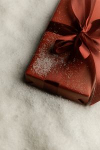 Kaboompics - Black Gift Box with Red Bow on Artificial Snow Close Up