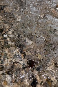 Kaboompics - Shallow Water Ripples over Pebbles with Reflective Coastal Texture