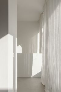 Kaboompics - Bright Minimalist Corner with Sheer Curtains and Geometric Shadows