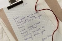 Kaboompics - Handwritten Letter on Graph Paper with Red String Close-Up