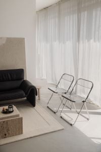 Kaboompics - Two Chrome Folding Chairs Beside a Black Sofa and Sheer Curtains