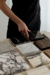 Kaboompics - Hand Positioning Black Marble Sample among Wood and Stone Materials