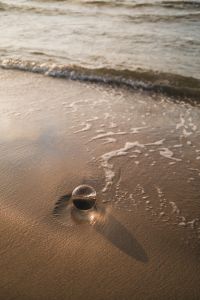 Kaboompics - Glass Sphere and Reflection on a Wet Shoreline