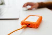 Kaboompics - Man works on a computer at his desk, mobile phone, portable hard drive