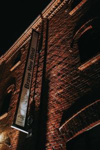 Kaboompics - Brick Exhibition Venue Facade with a Vertical Event Banner at Night