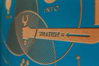 Kaboompics - Close-Up of Strategy Arrow and Information Icon on Blue and Tan Design Board