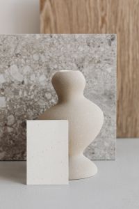 Kaboompics - Sculptural White Ceramic Vase beside Blank Card and Marble Sample, Vertical Branding Mockup