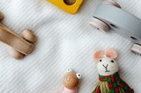 Kaboompics - Fabric Mouse Doll Beside Wooden Puzzle Cars and a Bead Toy