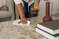 Kaboompics - Woman Cleaning a Marble Coffee Table with a Spray Bottle